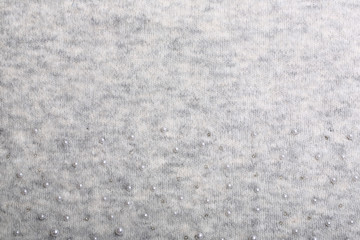 Knitted background. Light gray gentle wool background pattern. Background embroidered with beads