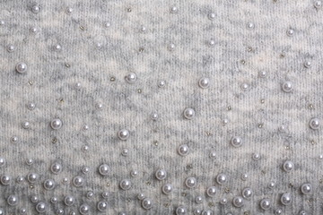 Knitted background. Light gray gentle wool background pattern. Background embroidered with beads