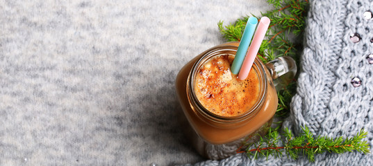 Christmas winter coffee with a spruce branch on a knitted gray background