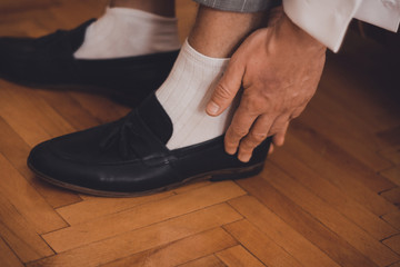 the groom sits on the wedding mornings