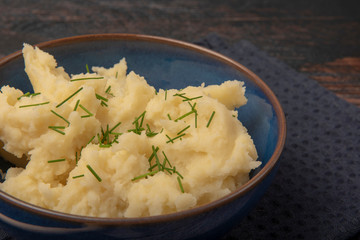 Bowl of mash potato topped with chives, taken with copy space