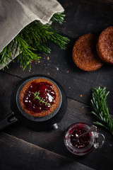 Little chocolate homemade muffin garnished with cherry jam. Dark moody style. Top view, selective focus