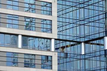 Obraz premium Modern building with reflected sky and cloud in glass window