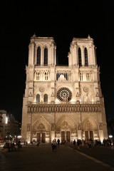 Fototapeta na wymiar facade of the Notre Dame cathedral in Paris by night with some tourists