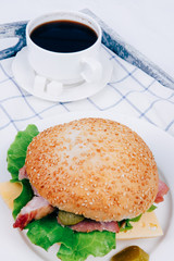 Tasty European snack hamburger sesame bun with ham and coffee