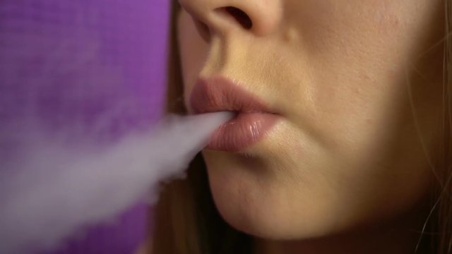 Close up of beautiful girl smokes the cigarette in slow motion.