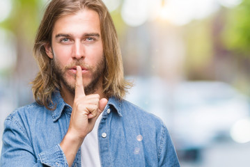 Fototapeta na wymiar Young handsome man with long hair over isolated background asking to be quiet with finger on lips. Silence and secret concept.