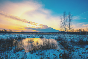 Winter snowy scenery. Snow covered field at sunset