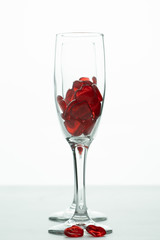 2 champagne flutes filled with red hearts one behind the other and  appearing within it