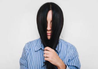 The young girl covered her face with hair. Hide from the problems. Introvert personality.