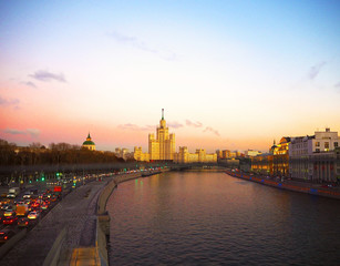 view of the sunset on the river, a residential skyscraper on Kotelnicheskaya Embankment, Moscow River, Bolshoy Ustinsky bridge. Moscow, Russia