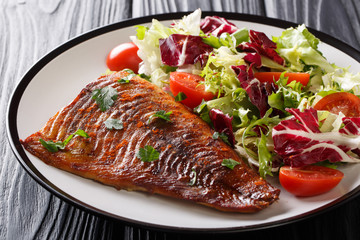 Tasty pike fillet and fresh vegetables close-up on a plate on the table. horizontal