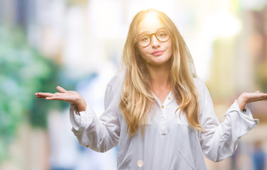 Young beautiful blonde business woman wearing glasses over isolated background clueless and...