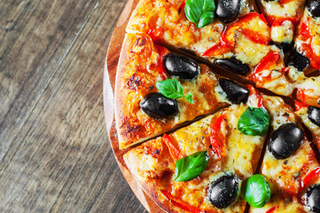 Pizza with Mozzarella cheese, Tomatoes, pepper, olive, Spices and Fresh Basil. Italian pizza. Pizza Margherita or Margarita on wooden table background