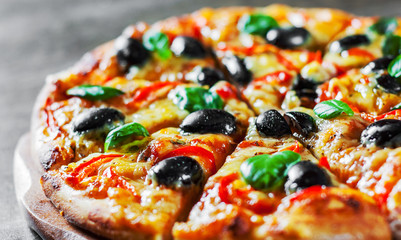 Pizza with Mozzarella cheese, Tomatoes, pepper, olive, Spices and Fresh Basil. Italian pizza. Pizza Margherita or Margarita on wooden table background