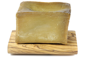 olive oil based hand-cut soap on underlay made of olive wood isolated on white background