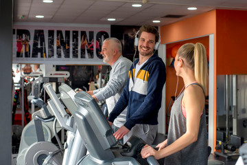 Friends having fun at the gym while exercising together on treadmill