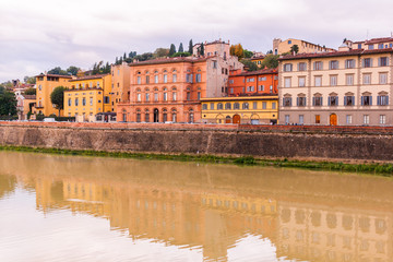 Colorful old buildings on the bank of Arno river in Florence, Italy with reflection in water. Medieval architecture