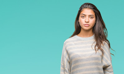 Young beautiful arab woman wearing winter sweater over isolated background with serious expression...