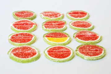 Marmalade slices in the form of watermelon and lime on a white background. Stand out from the crowd