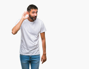 Adult hispanic man over isolated background smiling with hand over ear listening an hearing to rumor or gossip. Deafness concept.