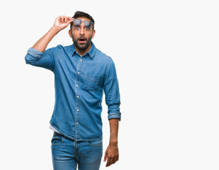 Fototapeta premium Adult hispanic man wearing sunglasses over isolated background afraid and shocked with surprise expression, fear and excited face.