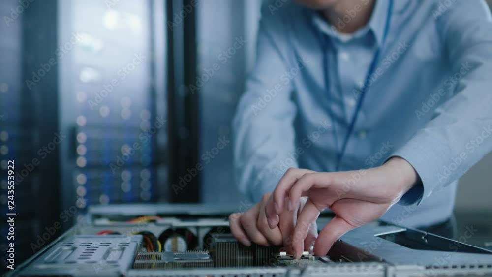 Aufkleber in the modern data center: it engineer wearing protective headphones installs new hardware for serve