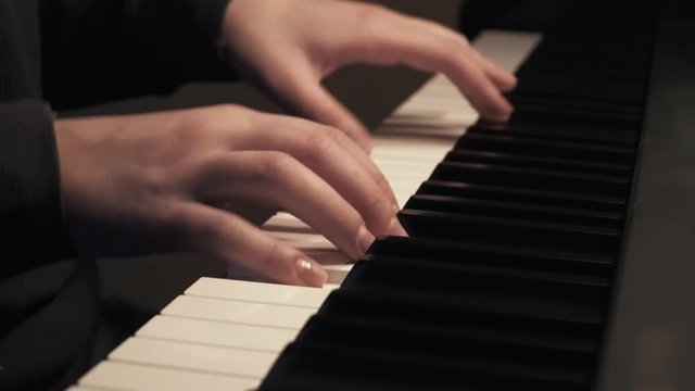 Female hands playing piano at normal speed. Mid view. Ending song