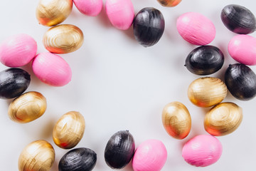 Black and gold eggs over white background.