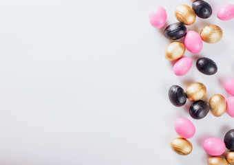 Black and gold eggs over white background.