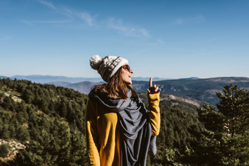 .Young and relaxed woman wearing a yellow sweater, enjoying a sunny winter day in the mountains. Carefree, free and calm. Lifestyle.