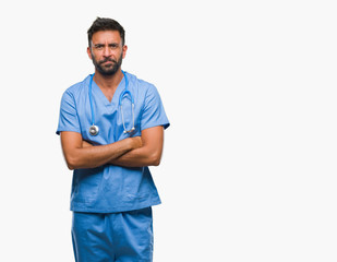 Adult hispanic doctor or surgeon man over isolated background skeptic and nervous, disapproving expression on face with crossed arms. Negative person.