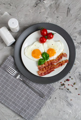 Tasty Fried Egg in the Shape of a Heart Served on a White Plate with Bacon Tomato Basil Pepper Gray Background Valentine Day Breakfast