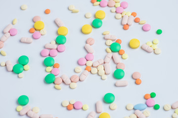 Green and yellow pills or capsules on a white background
