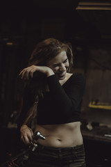 Naklejka na ściany i meble beautiful girl with long hair in the garage repairing a motorcycle