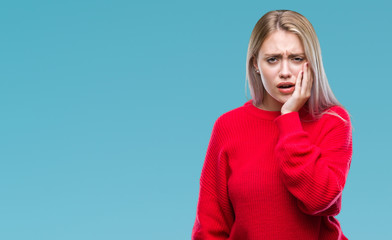 Young blonde woman wearing winter sweater over isolated background touching mouth with hand with...