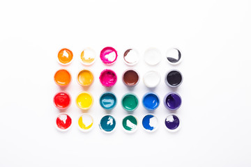 Multicolored gouache on a white background Isolated Paints in containers Top view Copy space