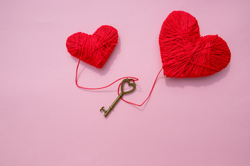 Bronze skeleton key and pink knitted hearts,antique rustic keys on pink background. Happy...