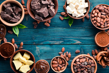 Chocolate, cocoa and cocoa beans on a blue wooden background. Top view. Free copy space.