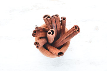 Sticks of cinnamon on a white wooden background. Top view. Free copy space.
