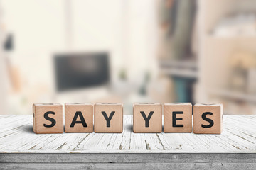 Say yes sign on a wooden desk in a bright room