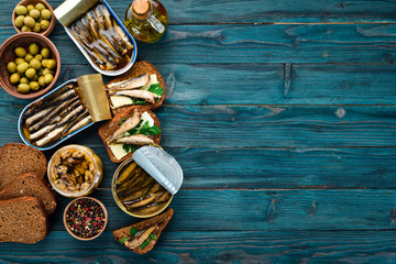 Sprats with oil in a jar. On a blue background. top view. Free copy space.