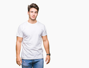 Young handsome man wearing white t-shirt over isolated background winking looking at the camera...