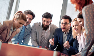 Coworkers playing table football on break