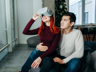 Obraz premium Young couple experiencing virtual reality (VR) in lounge room