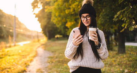 Young trendy woman blogger with coffee in park