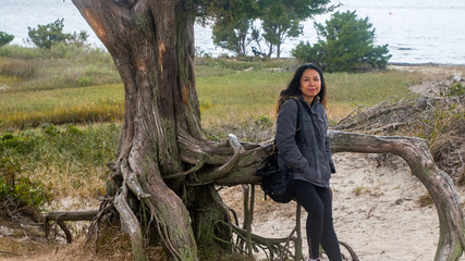 Asian woman with parka standing next to tree © David