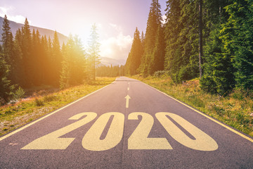 Empty asphalt road and New year 2020 concept. Driving on an empty road in the mountains to upcoming 2020 and leaving behind old 2019. Concept for success and passing time.