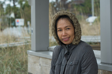 Asian woman in parka looking at photographer © David