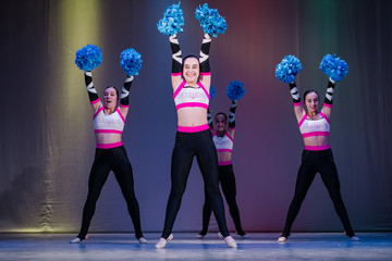 athletes take the stage, young cheerleaders perform at the cheerleading championship, hands raised...